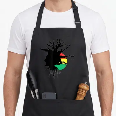 Tablier de cuisine noir avec silhouette de profil aux dreadlocks noires sur fond circulaire rouge jaune et vert.