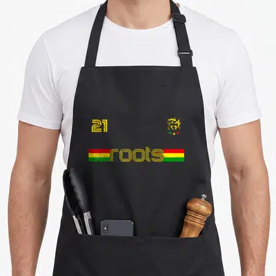 Tablier de cuisine noir avec inscription roots 21 et lion rastafari aux couleurs vert jaune rouge