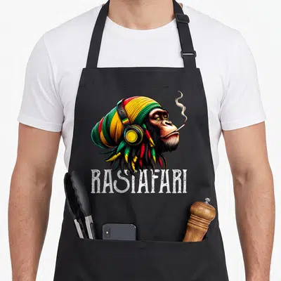 Tablier de cuisine noir avec illustration d'un chimpanzé Rastafari aux dreadlocks colorées et casque audio.