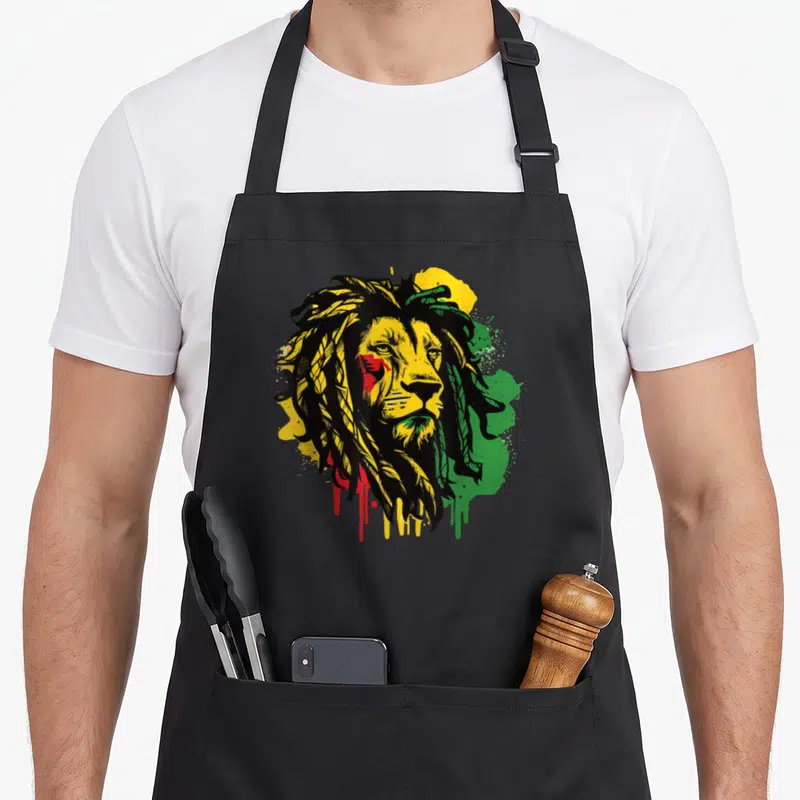 Tablier de cuisine noir avec tête de lion aux cheveux dreadlocks et couleurs Rasta jaune vert rouge