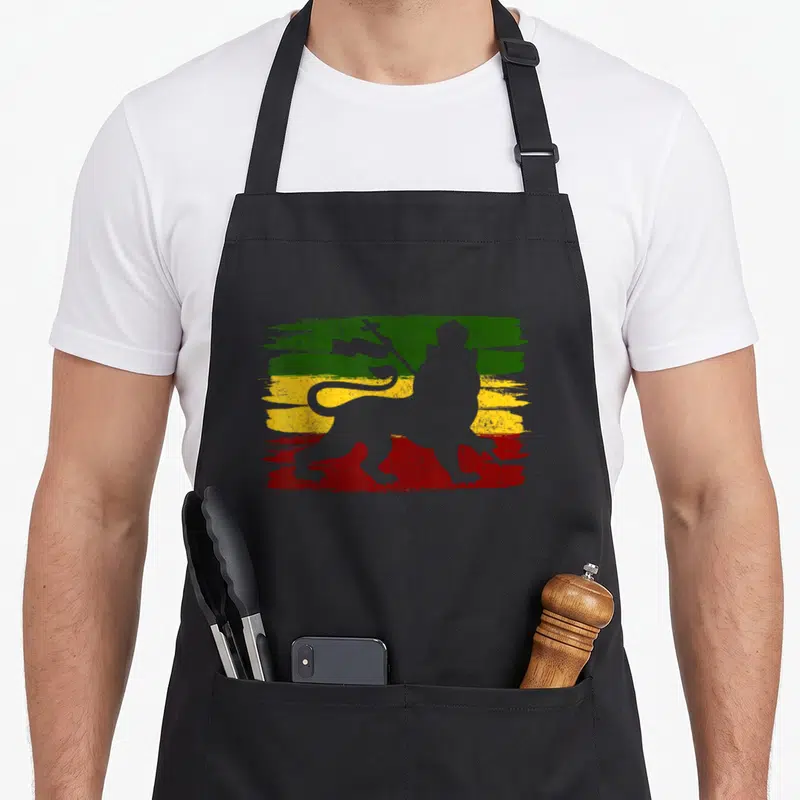 Tablier de cuisine noir avec silhouette lion de Juda sur fond aux couleurs vert jaune et rouge style brush.
