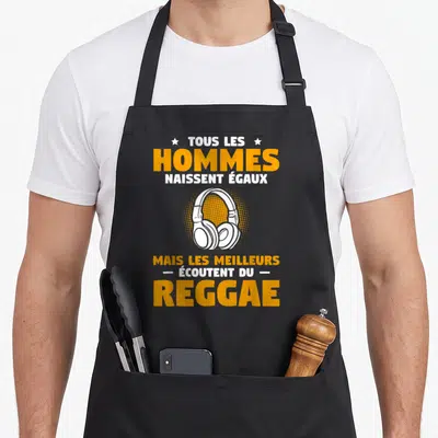 Tablier de cuisine noir avec inscription tous les hommes naissent égaux mais les meilleurs écoutent du reggae et un casque blanc.