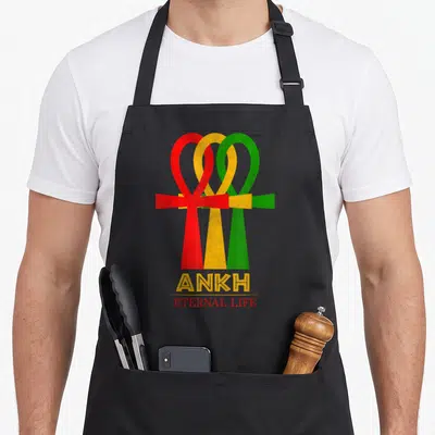 Tablier de cuisine noir avec trois symboles Ankh superposés aux couleurs Rasta et le texte Ankh Eternel Life en dessous.
