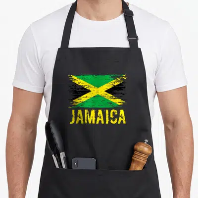 Tablier de cuisine noir avec drapeau Jamaica vintage et inscription JAMAICA en jaune.