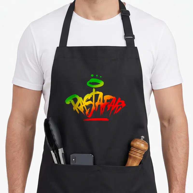 Tablier de cuisine noir avec inscription Rastafari en graffiti multicolore vert jaune et rouge sur le devant.