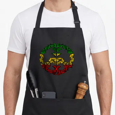 Tablier de cuisine noir avec un motif circulaire de papillons verts jaunes et rouges formant une structure symétrique.