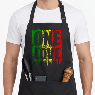 Tablier de cuisine noir avec le texte One Love en vert jaune et rouge style peinture éclaboussée.