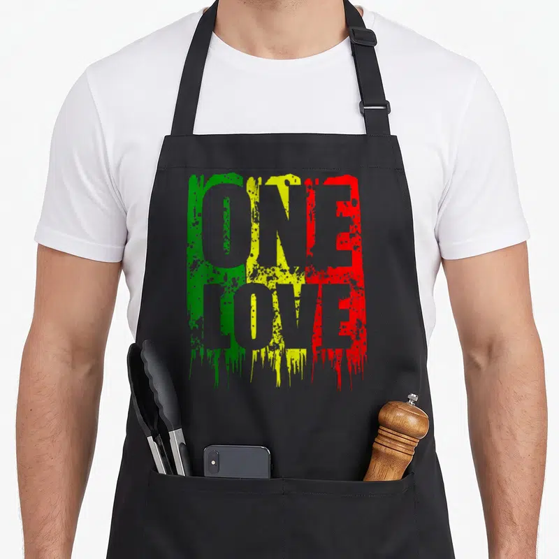 Tablier de cuisine noir avec le texte One Love en vert jaune et rouge style peinture éclaboussée.