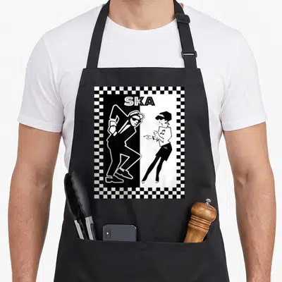 Tablier de cuisine noir avec illustration bichromie de deux danseurs ska sous l'inscription SKA encadrée d'un damier.