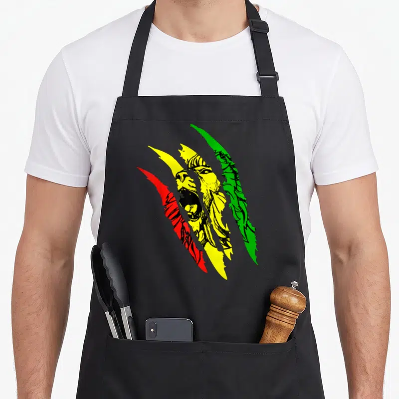 Tablier de cuisine noir avec un lion de Juda rugissant et des griffes aux couleurs rouge jaune et vert Rasta