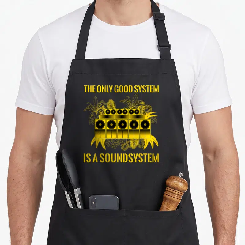 Tablier de cuisine noir avec illustration jaune d'un soundsystem tropical et texte anglais.