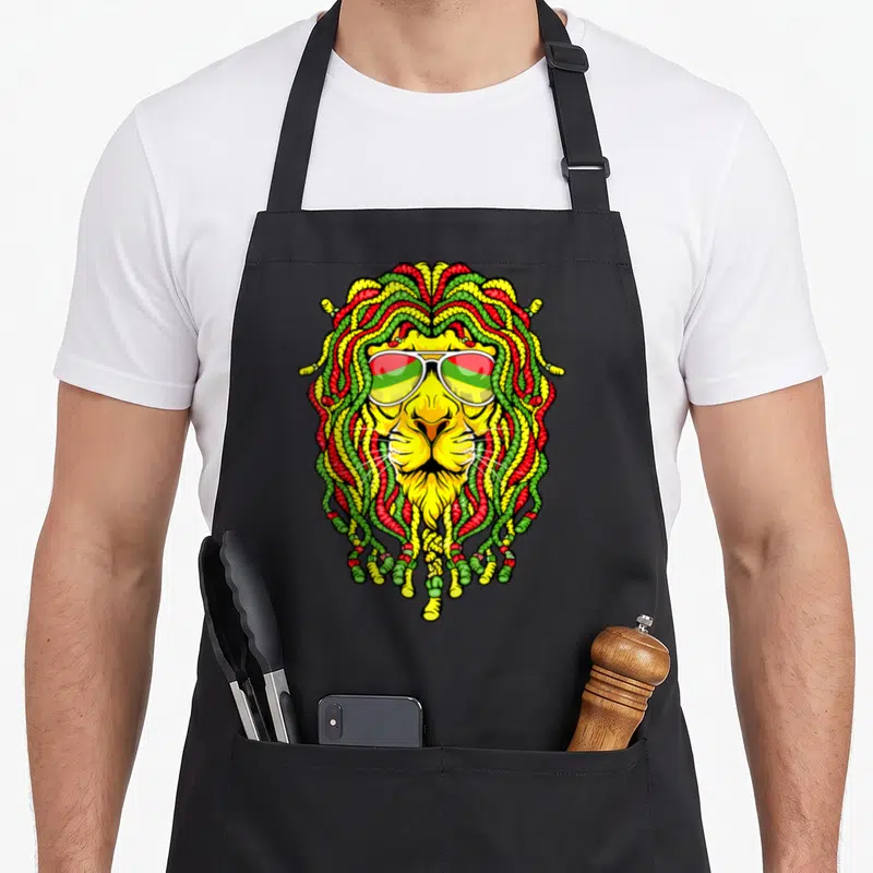 Tablier de cuisine noir avec un lion aux dreadlocks rasta et lunettes de soleil aux verres tricolores.