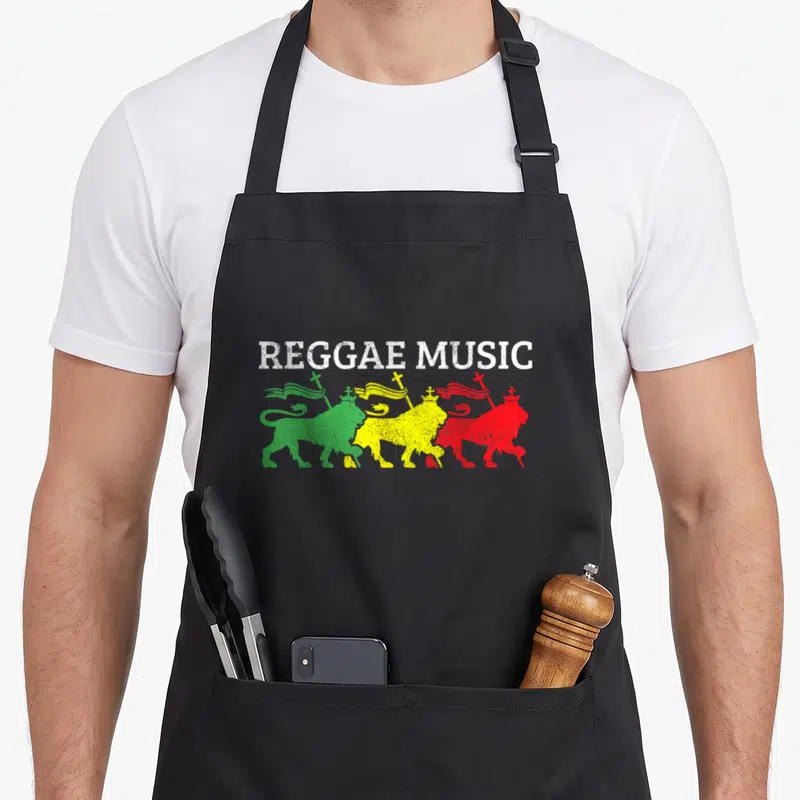 Tablier de cuisine noir avec inscription Reggae Music et trois lions de Juda colorés porteurs de drapeaux.