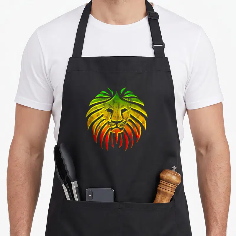 Tablier de cuisine noir avec illustration d'un lion aux cheveux stylisés verts jaunes et rouges dans un style vintage.