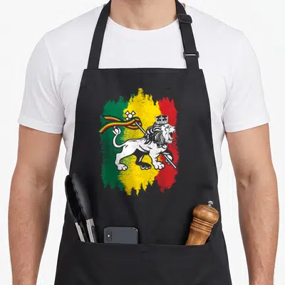 Tablier de cuisine noir avec illustration Lion of Judah sur fond de couleurs Rasta vert jaune et rouge.