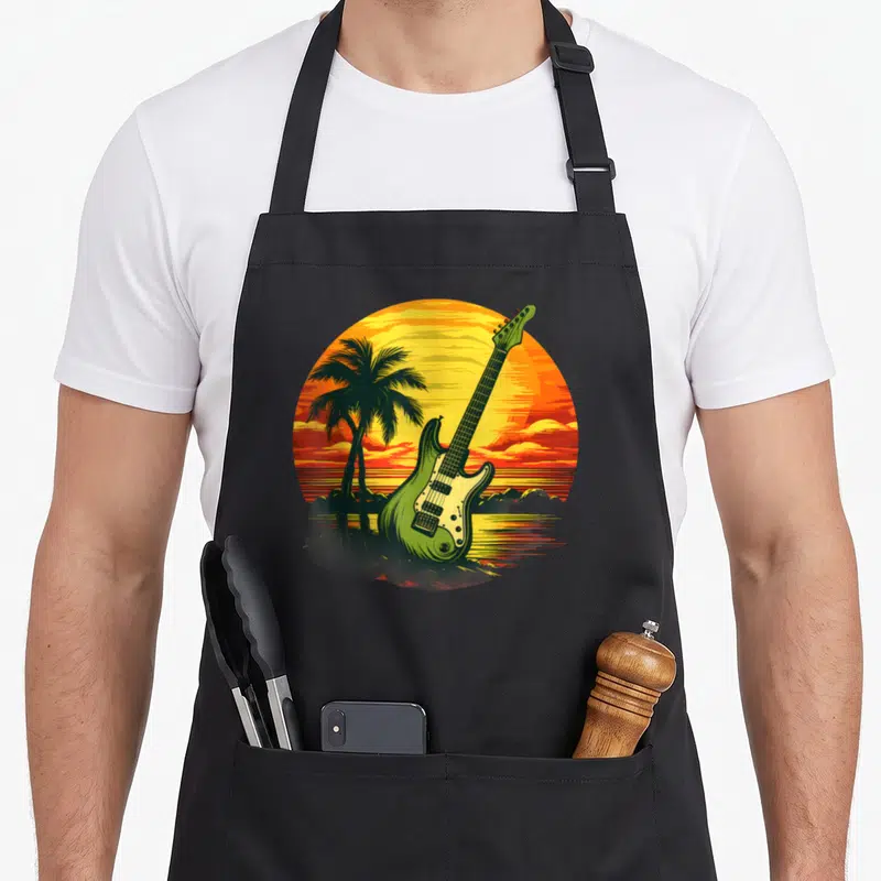Tablier de cuisine noir avec une guitare verte, des palmiers et un soleil couchant aux couleurs Rasta.
