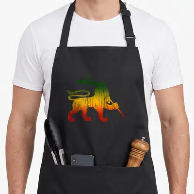 Tablier de cuisine noir avec illustration Lion of Judah aux couleurs rastafari vert jaune et rouge.
