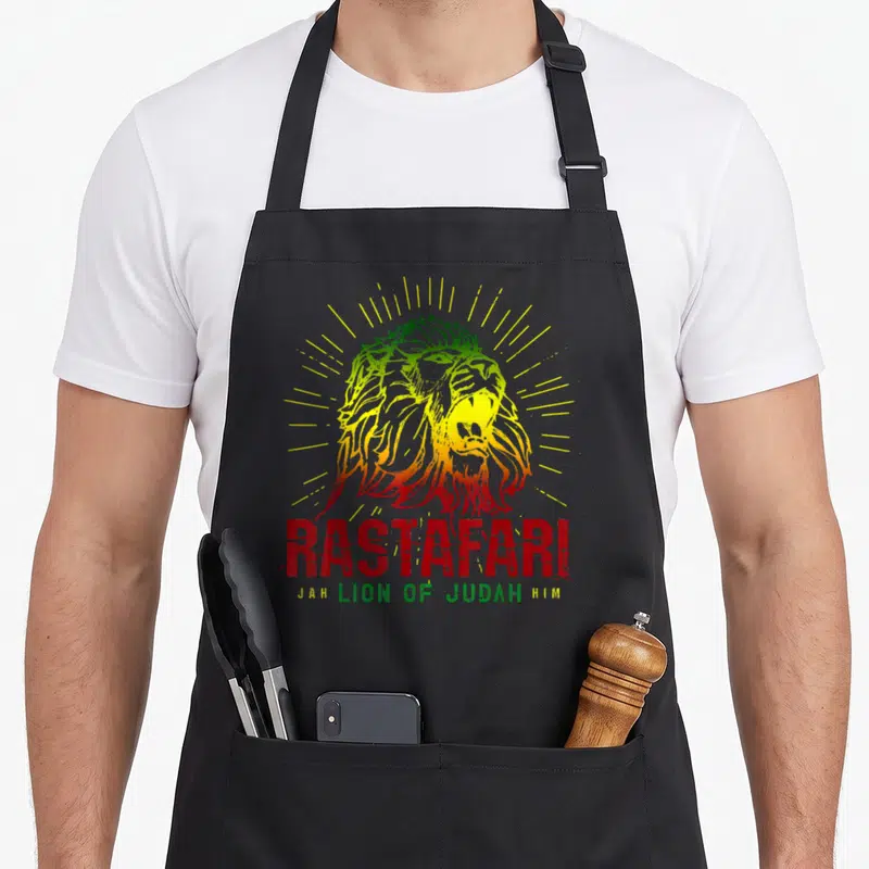 Tablier de cuisine noir avec illustration d'un lion Rastafari aux couleurs vert jaune et rouge et le mot RASTAFARI en rouge