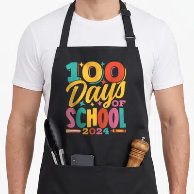 Tablier de cuisine noir avec inscription 100 Days of School 2024 et illustrations de crayons de couleur.