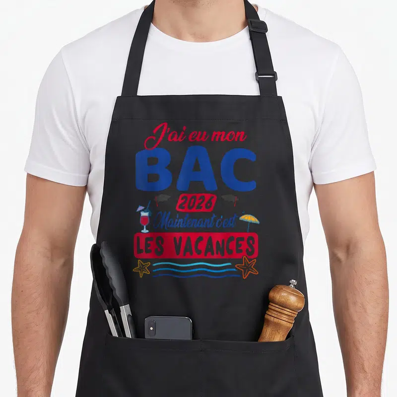 Tablier de cuisine noir avec inscription J'ai eu mon Bac 2026 et illustrations de plage colorées.