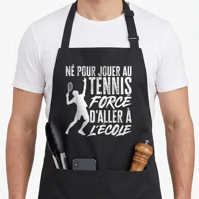 Tablier de cuisine noir avec une silhouette blanche de joueur de tennis et un texte humoristique sur la rentrée.