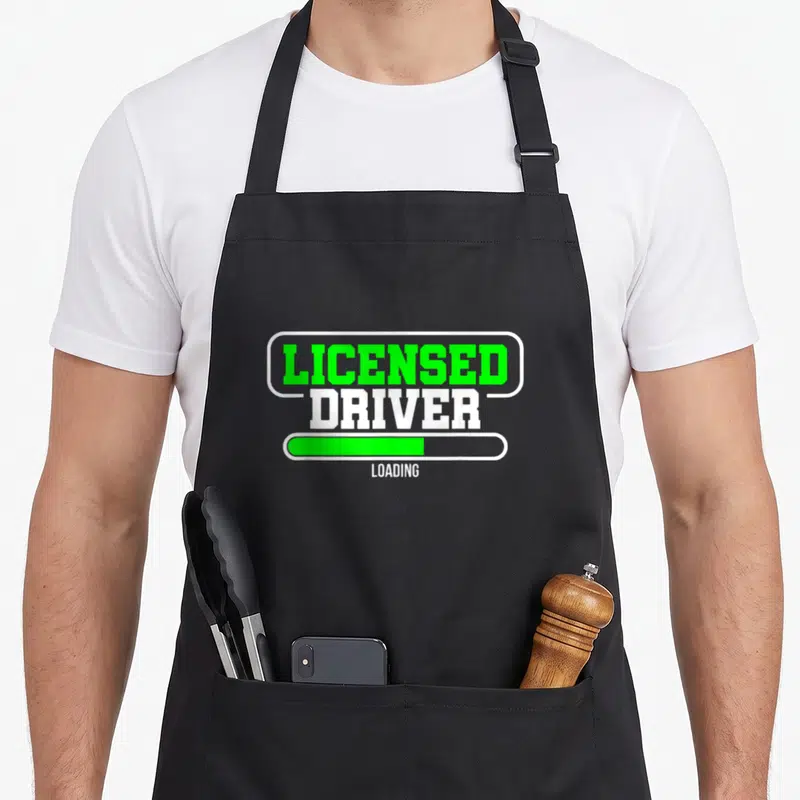 Tablier de cuisine noir avec inscription « Licensed Driver Loading » et barre de progression verte.