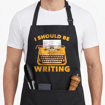 Tablier de cuisine noir avec illustration vintage d'une machine à écrire jaune et texte en anglais.