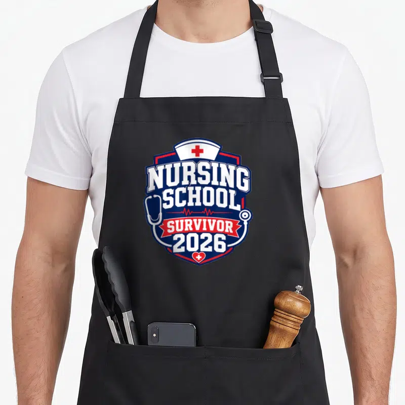 Tablier de cuisine noir avec motif badge nursing school survivor 2026 en bleu et rouge.