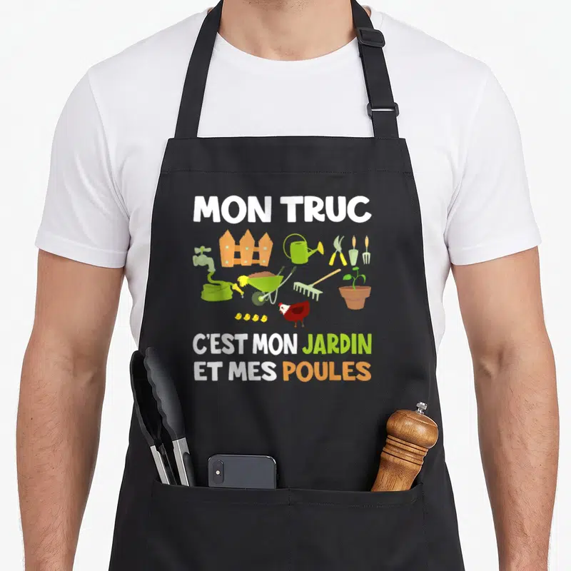 Tablier de cuisine noir avec illustration colorée d'outils de jardinage et une poule accompagnée du texte Mon truc c'est mon jardin et mes poules.