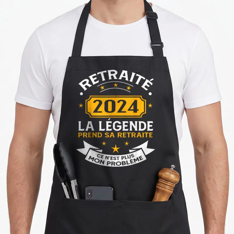 Tablier de cuisine noir avec inscription Retraité 2024 la légende prend sa retraite et ce n'est plus mon problème sur fond gris uni.