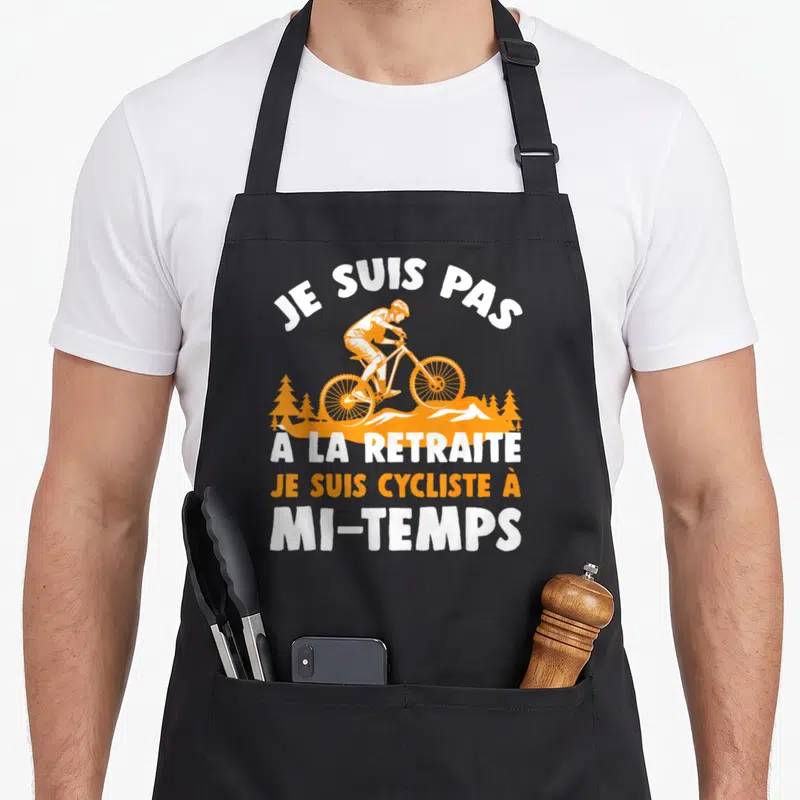 Tablier de cuisine noir avec illustration orange d'un cycliste et texte blanc Je suis pas à la retraite je suis cycliste à mi-temps