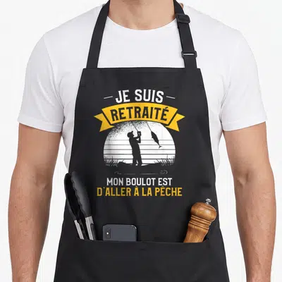 Tablier de cuisine noir avec silhouette de pêcheur et texte Je suis retraité mon boulot est d'aller à la pêche en jaune et gris.