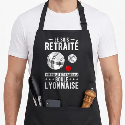 Tablier de cuisine noir avec texte blanc Je suis retraité Boule lyonnaise et illustration de boules de jeu.