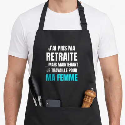 Tablier de cuisine noir avec inscription blanche et bleue sur le thème de la retraite et du travail domestique.