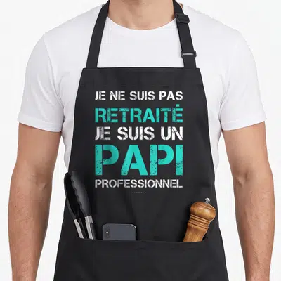 Tablier de cuisine noir avec le texte Je ne suis pas retraité je suis un papi professionnel en blanc et turquoise.