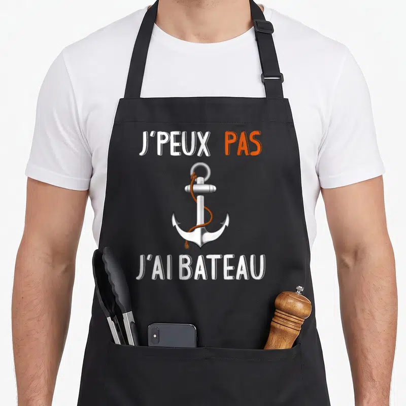 Tablier de cuisine noir avec ancre argentée, corde orange et texte J'peux pas j'ai bateau.