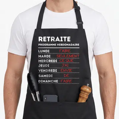 Tablier de cuisine noir avec programme hebdomadaire texte blanc et rouge sur fond gris uni.