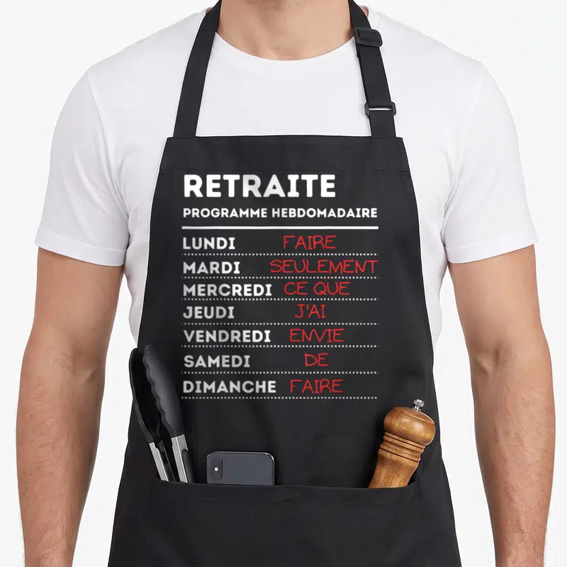 Tablier de cuisine noir avec programme hebdomadaire texte blanc et rouge sur fond gris uni.