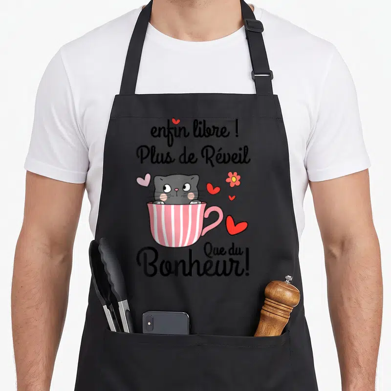Tablier de cuisine noir avec un chat gris dans une tasse rose et des cœurs colorés.