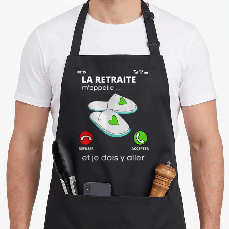 Tablier de cuisine noir avec illustration d'écran de téléphone affichant des chaussons à cœur et texte sur la retraite