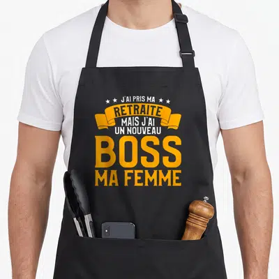 Tablier de cuisine noir avec inscription orange et blanche J'ai pris ma retraite mais j'ai un nouveau boss ma femme.