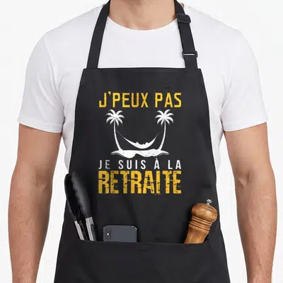 Tablier de cuisine noir avec inscription J'peux pas je suis à la retraite et hamac entre palmiers