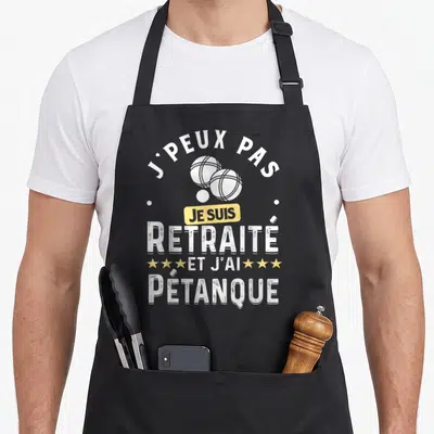 Tablier de cuisine noir avec inscription J'peux pas je suis retraité et j'ai pétanque et illustration de boules blanches.