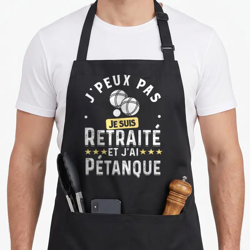 Tablier de cuisine noir avec inscription J'peux pas je suis retraité et j'ai pétanque et illustration de boules blanches.