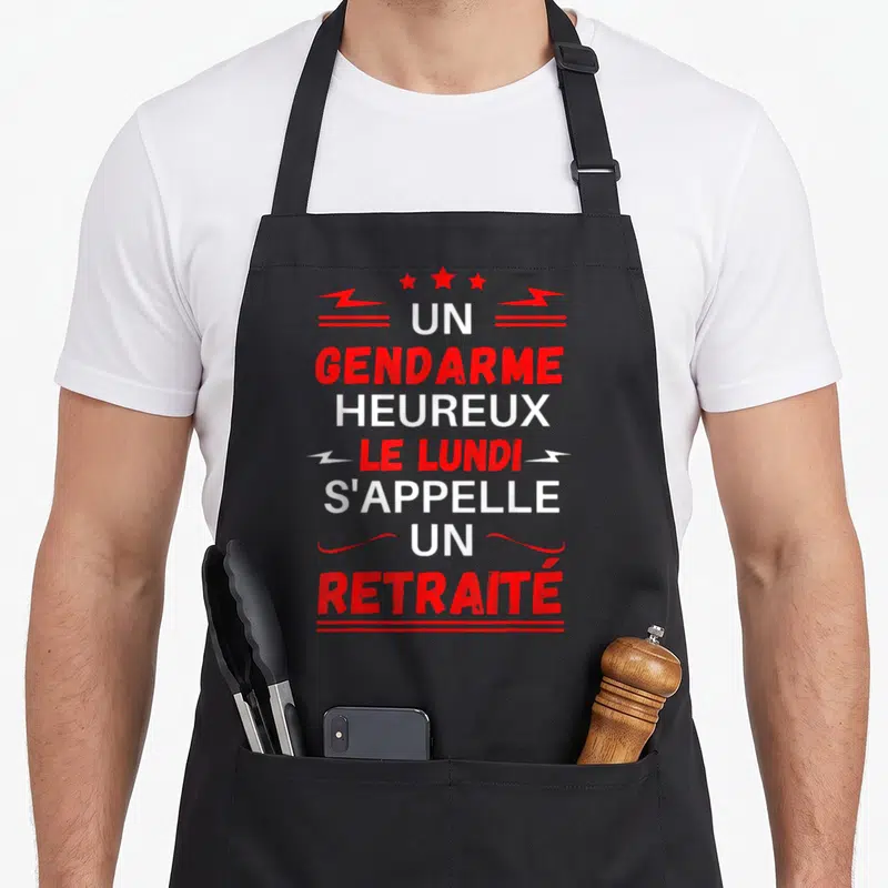 Tablier de cuisine noir avec texte rouge et blanc un gendarme heureux le lundi s'appelle un retraité orné d'étoiles et éclairs.