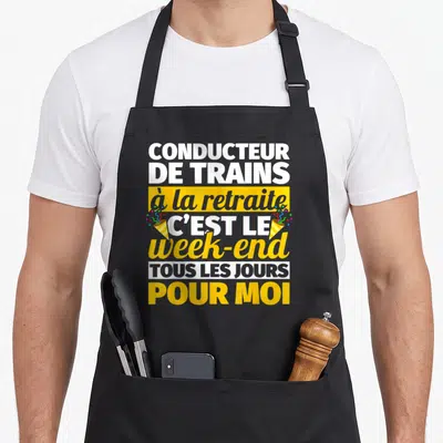 Tablier de cuisine noir avec texte blanc et jaune célébrant la retraite des conducteurs de trains.