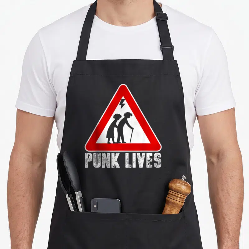 Tablier de cuisine noir avec triangle rouge signalant des silhouettes punk âgées et le texte Punk Lives en bas.