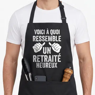 Tablier de cuisine noir avec inscription blanche Voici à quoi ressemble un retraité heureux et deux doigts pointant vers le bas.