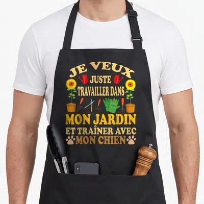 Tablier de cuisine noir avec inscription Je veux juste travailler dans mon jardin et traîner avec mon chien entourée d'outils de jardinage et de fleurs.