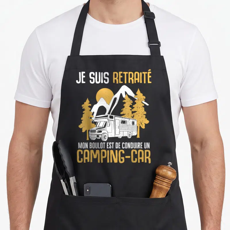 Tablier de cuisine noir avec inscription Je suis retraité mon boulot est de conduire un camping-car et illustration de véhicule dans les montagnes.